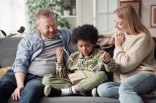 parents hanging with child on couch